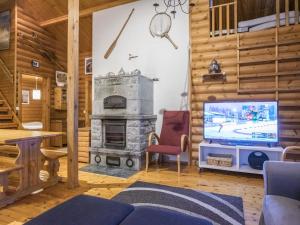 a living room with a television and a fireplace at Holiday Home Rannantupa by Interhome in Hersala