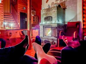 a person with their feet up in a room with a fireplace at Holiday Home Rannantupa by Interhome in Hersala