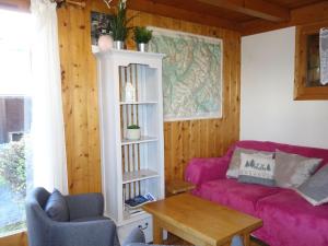 un soggiorno con divano rosa e tavolo di Holiday Home Les Farfadets by Interhome a Saint-Gervais-les-Bains