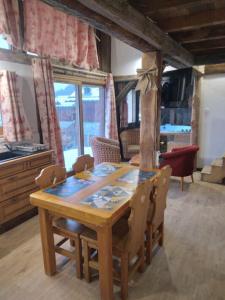 a wooden table and chairs in a living room at Chalet La Plagne jacuzzi vue top in Montchavin