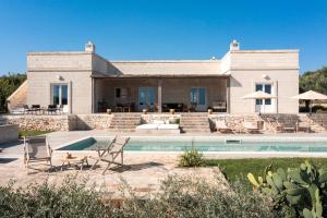 a house with a pool in front of it at Villa Margareta in Ostuni