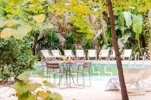 a table and chairs next to a swimming pool at Aspasios Garden Apartments in Barcelona