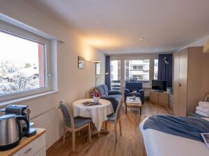 Apartment Chesa Corvatsch 111 - Champfer by Interhome في سورليج: غرفة بسرير وطاولة وكراسي
