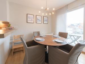 a dining room with a wooden table and chairs at Apartment Residentie Havenhuys-2 by Interhome in Bredene