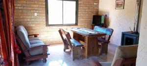 a room with a table and chairs and a television at Cabaña Casablanca in La Granja