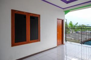 Habitación con balcón con ventana y puerta. en Urbanview Syariah Zidney 3 Salatiga by RedDoorz, en Salatiga
