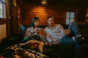 a man and a woman sitting on a couch at Fuente del Lobo Glamping & Bungalows - Adults Only in Pinos Genil