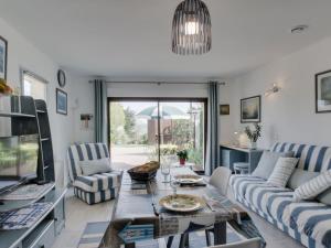 a living room with a couch and a table at Studio Les Genêts by Interhome in La Richardais +9 photos