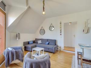 uma sala de estar com um sofá azul e uma mesa em Apartment Basse Vallée by Interhome em Dinard