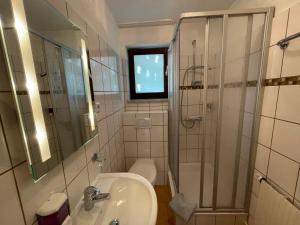 a bathroom with a sink and a shower and a toilet at Apartment Ferienpark Himmelberg-4 by Interhome in Thalfang