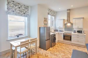 a kitchen with a table and a stainless steel refrigerator at Host & Stay - 2 Maritime Apartments in Scarborough