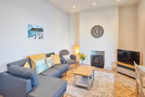 a living room with a couch and a tv at Host & Stay - 2 Maritime Apartments in Scarborough