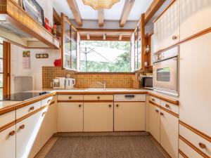 a kitchen with white cabinets and a window at Holiday Home Marguerite by Interhome in Capbreton