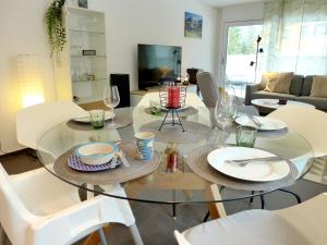 a dining room with a glass table and white chairs at Apartment Terrasse by Interhome in Kandersteg