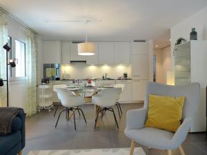 een keuken en een woonkamer met een tafel en stoelen bij Apartment Terrasse by Interhome in Kandersteg