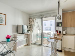 a kitchen with a table and chairs in a room at Apartment Le Newport-2 by Interhome in Fréjus