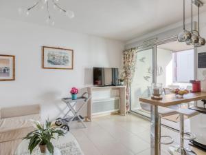 a living room with a couch and a table at Apartment Le Newport-2 by Interhome in Fréjus