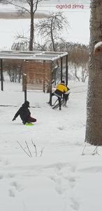dwoje ludzi bawiących się w śniegu w parku w obiekcie Stacja Mazury(Masuria Station) w mieście Narty