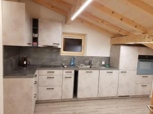 a kitchen with white cabinets and a sink at Apartment Lischa by Interhome in Fiesch