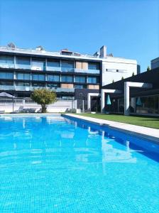 a large swimming pool in front of a building at Espectacular apartamento con piscina y garaje in Madrid