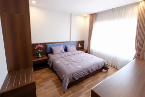 a bedroom with a bed with a blue bedspread at Viet Long Complex Residence in Bắc Ninh