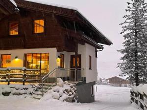 una casa en la nieve con un árbol en Chalet Chalet Elisabeth by Interhome, en Juns