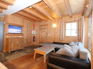 a living room with a couch and a tv at Chalet Chalet Elisabeth by Interhome in Juns