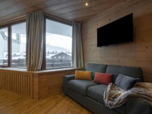 a living room with a couch and a flat screen tv at Apartment Les Genepis-5 by Interhome in Tignes