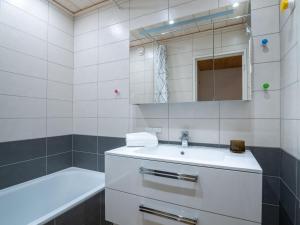 a white bathroom with a sink and a bath tub at Apartment Les Genepis-5 by Interhome in Tignes