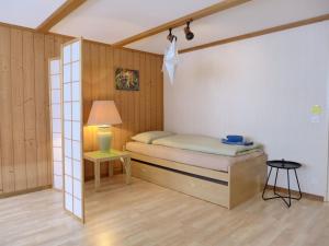 um pequeno quarto com uma cama e um candeeiro em Apartment Chalet im Gässli by Interhome em Lauterbrunnen