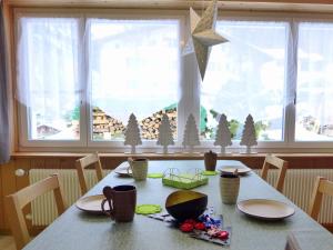 a dining room table with christmas decorations on it at Apartment Chalet im Gässli by Interhome in Lauterbrunnen +20 photos