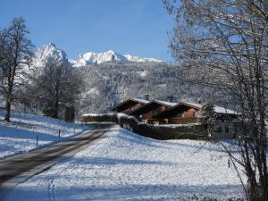 a snow covered road leading to a log cabin at Holiday Home Haus Sigfried by Interhome in Bischofshofen