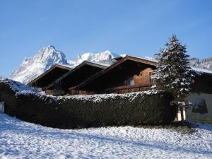a log cabin in the snow with a christmas tree at Holiday Home Haus Sigfried by Interhome in Bischofshofen