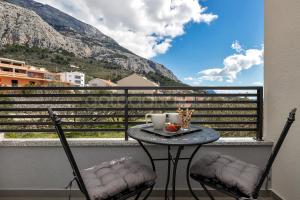 a table and two chairs on a balcony with a view at Newly Built Apartment Luka in Makarska