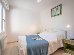 sypialnia z łóżkiem i książką na nim w obiekcie Apartment L'Escale by Interhome w Fréjus