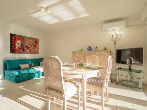 salon ze stołem, krzesłami i kanapą w obiekcie Apartment L'Escale by Interhome w Fréjus