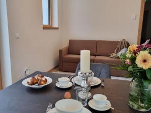 a dining room table with a candle and a table with food at Apartment Alpenschnucke Home by Interhome in See