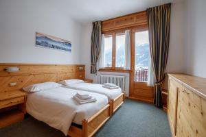 a bedroom with a bed and a large window at Residence Sci Sport in Bormio