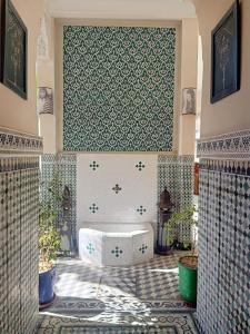 a bathroom with a tub in the middle of a room at Riad 4 jardins in Marrakesh