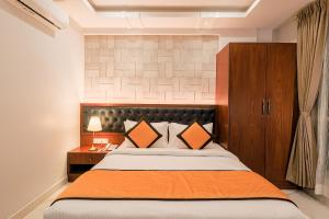 a bedroom with a large bed with an orange blanket at La Serene Boutique Hotel - Manyata Tech Park in Bangalore