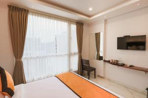 a hotel room with a bed and a large window at La Serene Boutique Hotel - Manyata Tech Park in Bangalore