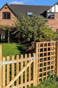 a wooden fence in front of a house at Seaside Cottage, 8min walk to beach. Dog friendly. in Norwich