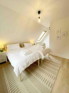 a bedroom with a white bed and a window at Seaside Cottage, 8min walk to beach. Dog friendly. in Norwich