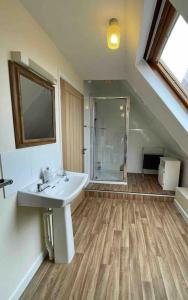 a bathroom with a white sink and a shower at Seaside Cottage, 8min walk to beach. Dog friendly. in Norwich