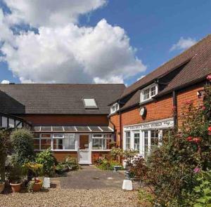 a brick building with a garden in front of it at Seaside Cottage, 8min walk to beach. Dog friendly. in Norwich