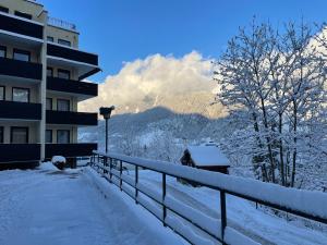 un edificio coperto di neve accanto a una recinzione di Grenzberg Top 20 a Bad Gastein