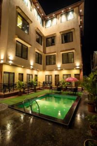 a swimming pool in front of a building at Jivanta Mahabaleshwar in Mahabaleshwar