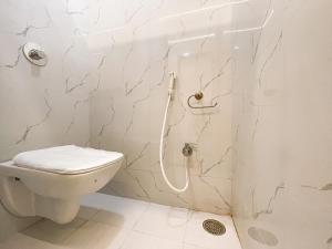 a white bathroom with a toilet and a shower at Hotel Ashirwad, Solapur in Solapur