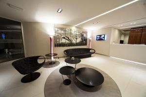 a living room with black chairs and a couch at Albergo Dei Laghi in Turate