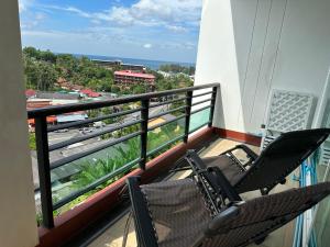 two chairs on a balcony with a view of the ocean at Phuket Condominium Karon beach in Karon Beach